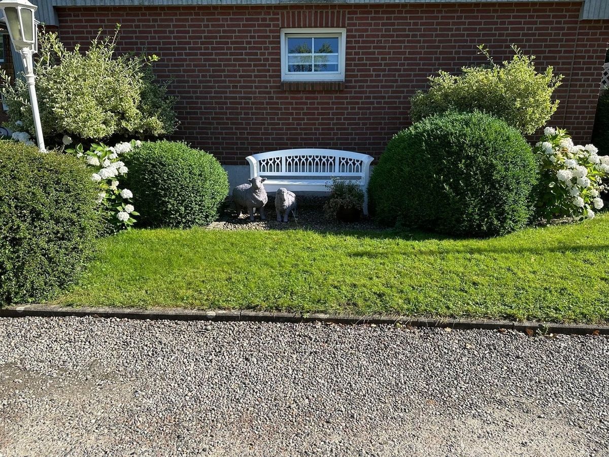 weiße Bank im Garten vor einem Haus